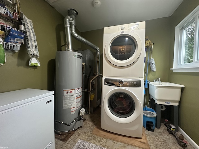 laundry area with gas water heater, stacked washing maching and dryer, sink, and light tile patterned floors