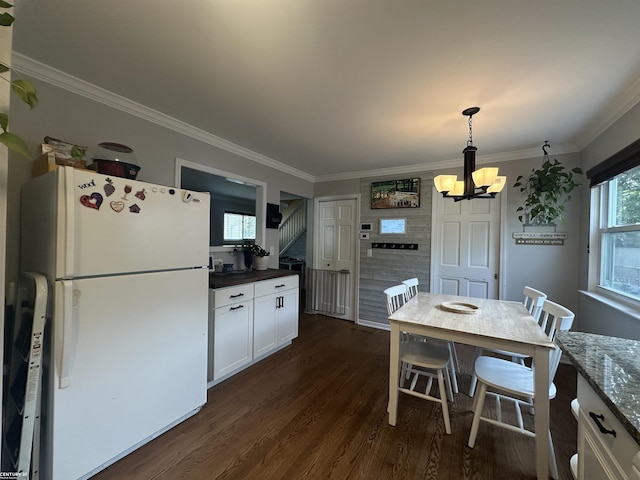 kitchen featuring white refrigerator, decorative light fixtures, dark stone countertops, dark hardwood / wood-style floors, and white cabinetry