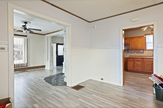 unfurnished room with ceiling fan, sink, light wood-type flooring, and ornamental molding