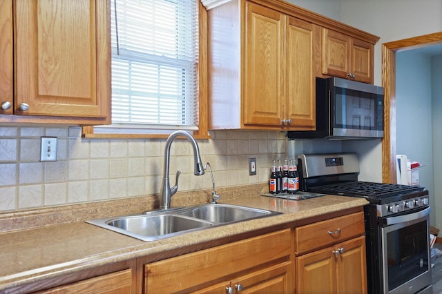 kitchen with appliances with stainless steel finishes, tasteful backsplash, and sink