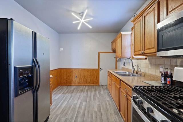 kitchen with appliances with stainless steel finishes, light hardwood / wood-style floors, and sink