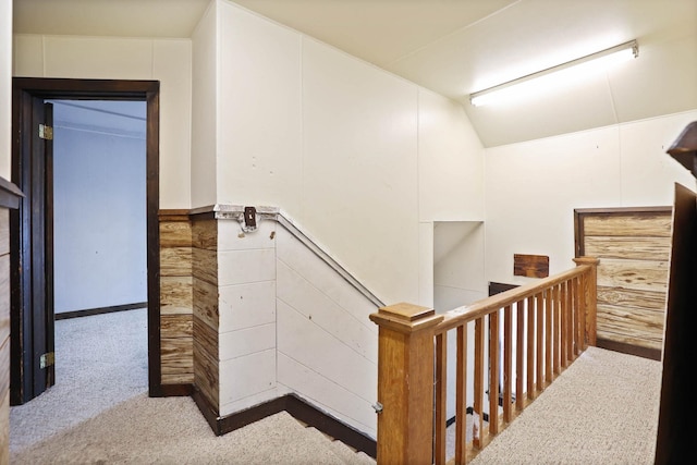 stairway featuring lofted ceiling and carpet floors