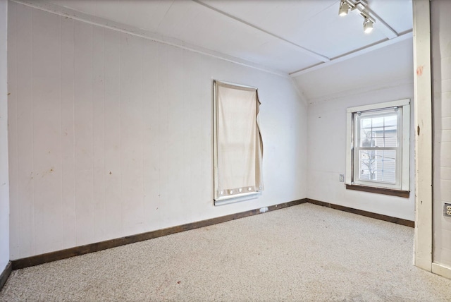 spare room with carpet floors and vaulted ceiling