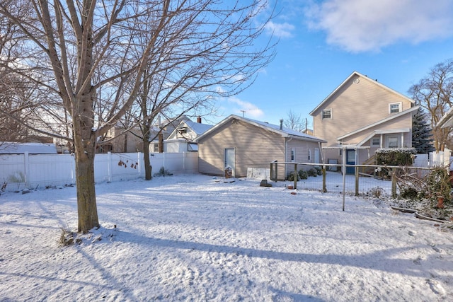 view of snow covered back of property