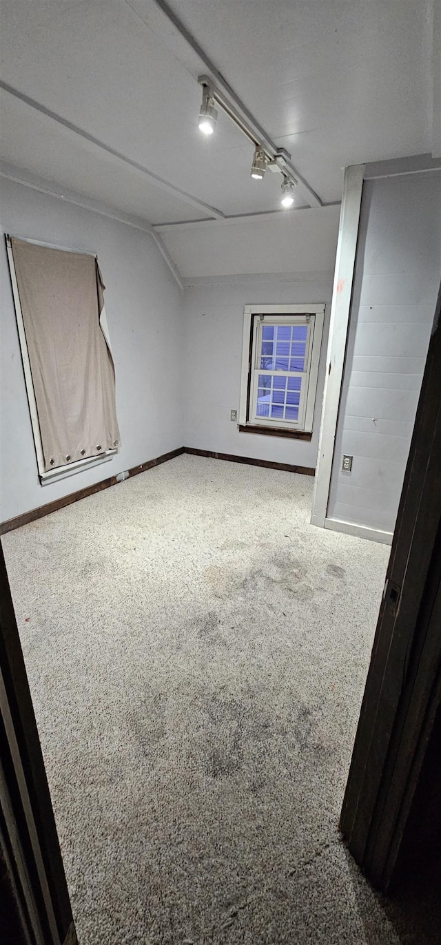 empty room featuring carpet flooring and lofted ceiling