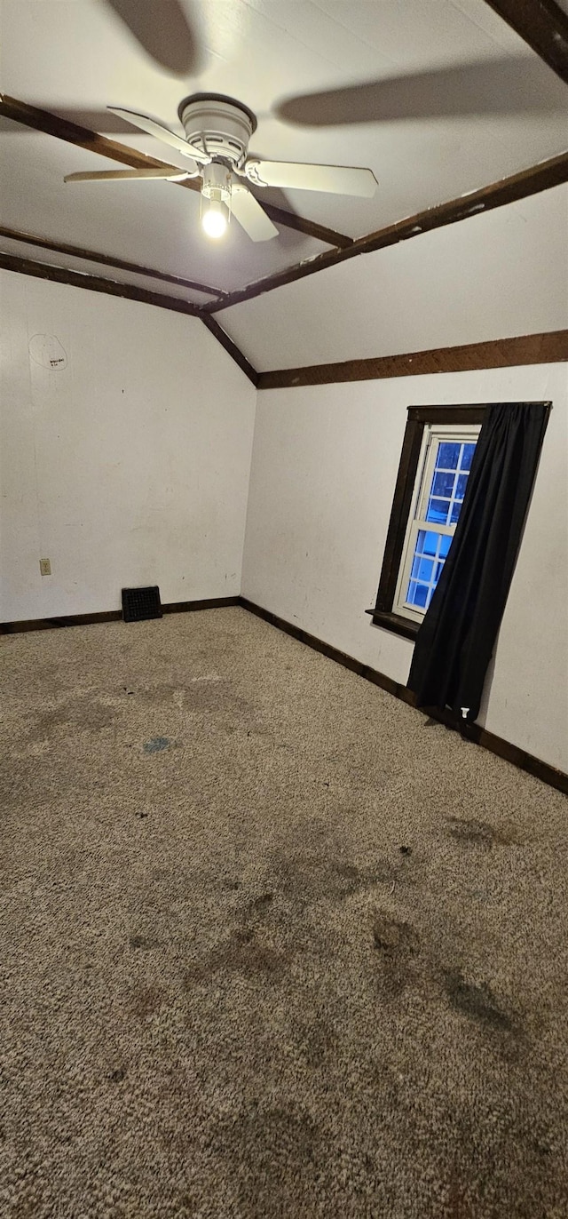 carpeted empty room with ceiling fan and lofted ceiling