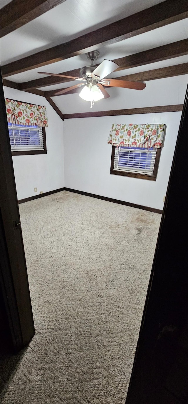 spare room with ceiling fan, carpet, and lofted ceiling with beams