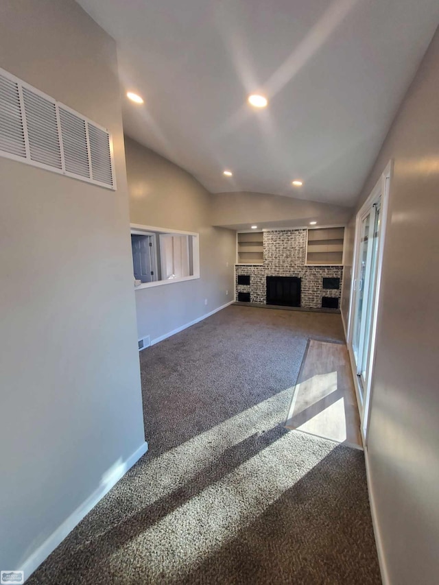 unfurnished living room with a fireplace, carpet, and vaulted ceiling