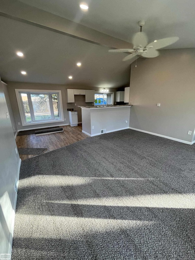 unfurnished living room with dark carpet and ceiling fan