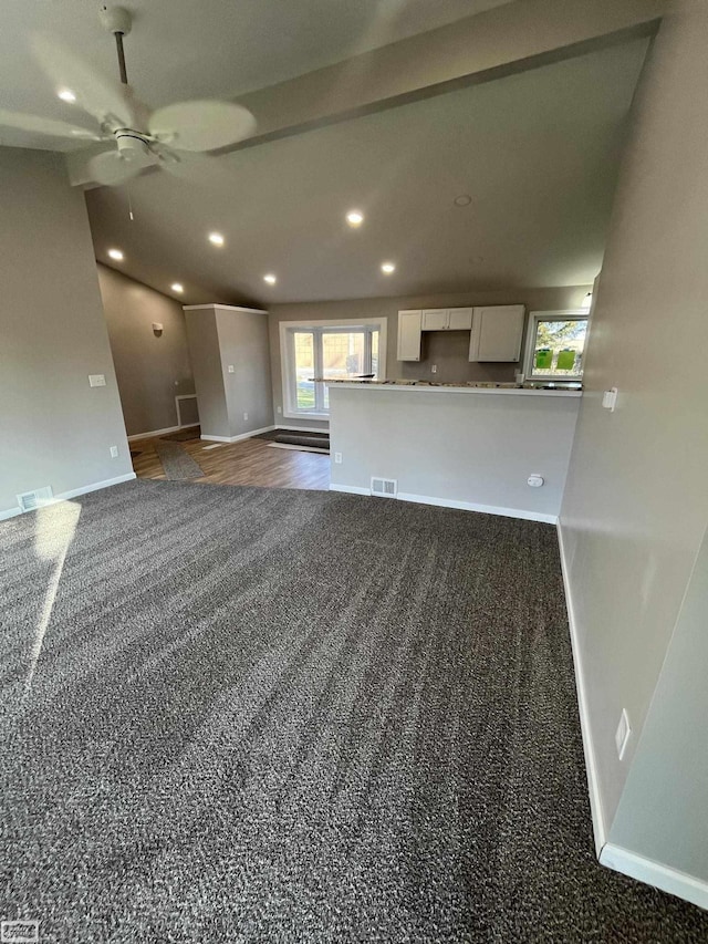 unfurnished living room with dark carpet and ceiling fan