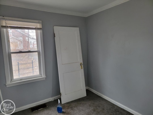 spare room featuring dark carpet and ornamental molding