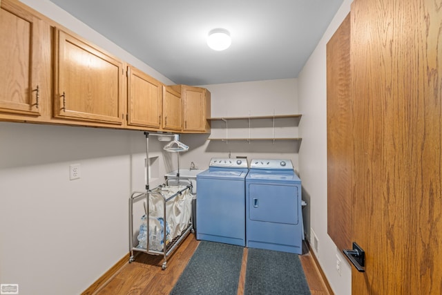 laundry room with hardwood / wood-style floors, cabinets, and independent washer and dryer