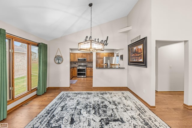 interior space featuring light hardwood / wood-style flooring, an inviting chandelier, and a wealth of natural light