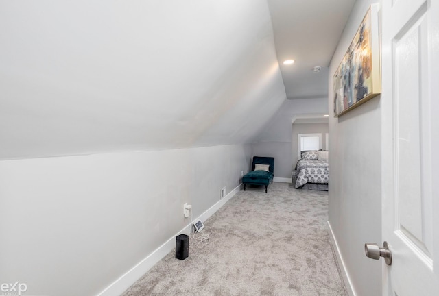 bedroom featuring light colored carpet and vaulted ceiling