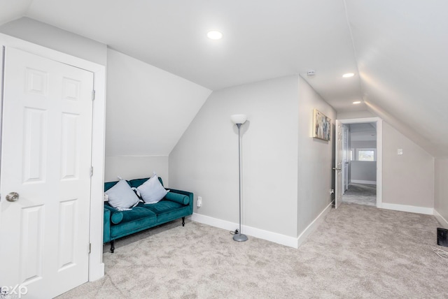 sitting room with light colored carpet and vaulted ceiling