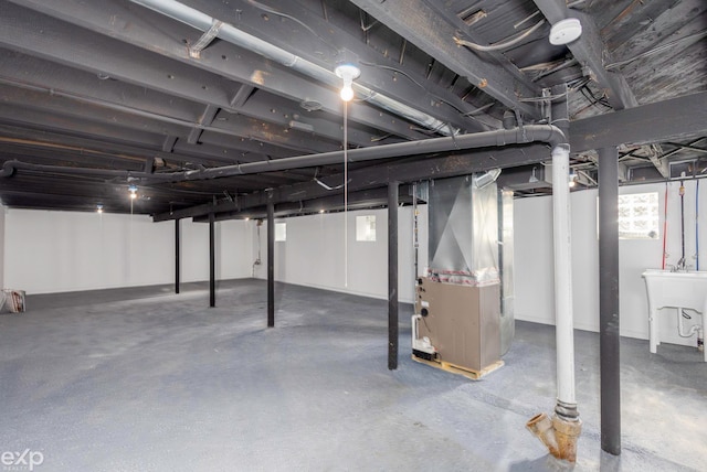 basement featuring heating unit and sink