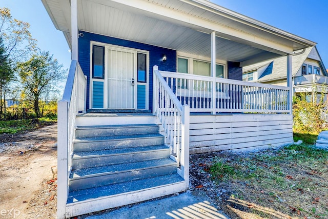 view of exterior entry featuring covered porch