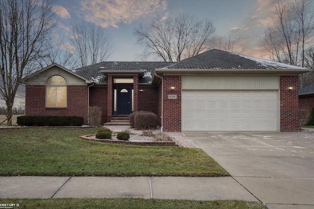 ranch-style home featuring a lawn and a garage