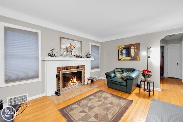 living room with hardwood / wood-style flooring and a brick fireplace