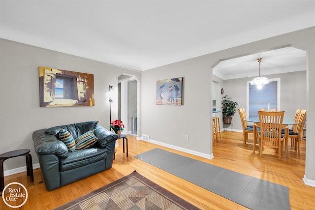 living room with hardwood / wood-style flooring and a notable chandelier