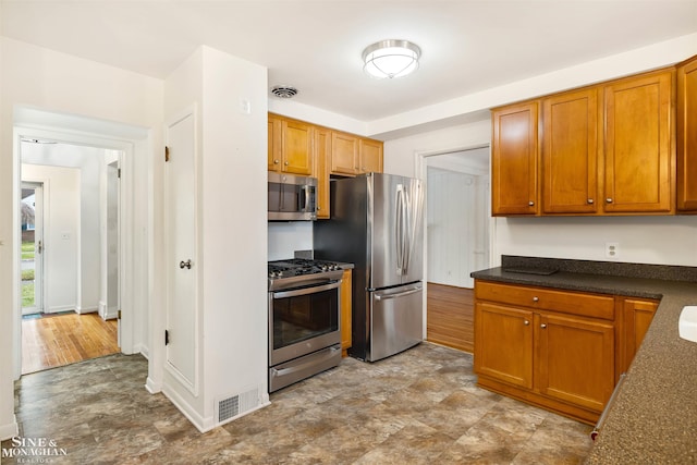 kitchen with appliances with stainless steel finishes and light hardwood / wood-style flooring