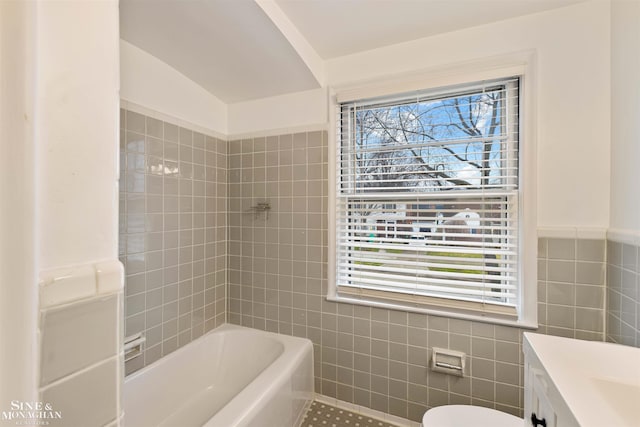 bathroom with vanity, toilet, tile walls, and lofted ceiling