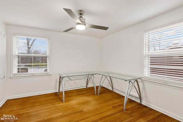 unfurnished office featuring wood-type flooring, plenty of natural light, and ceiling fan