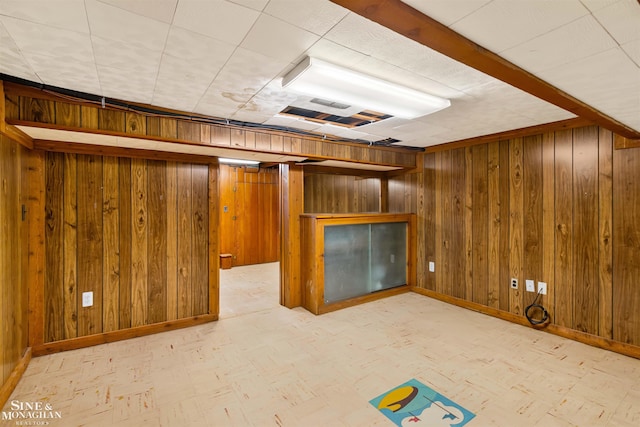 basement featuring wooden walls