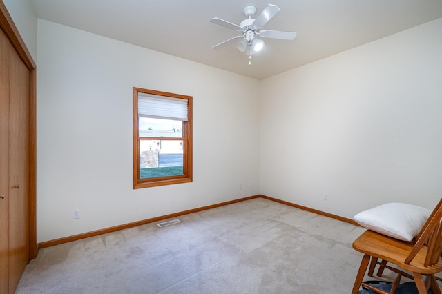 interior space with ceiling fan and light colored carpet