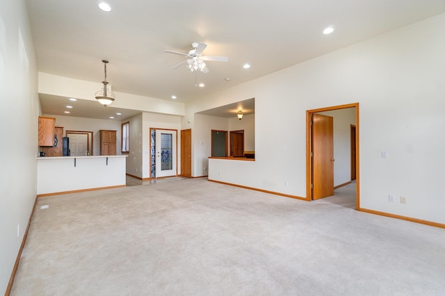 unfurnished living room featuring light colored carpet and ceiling fan