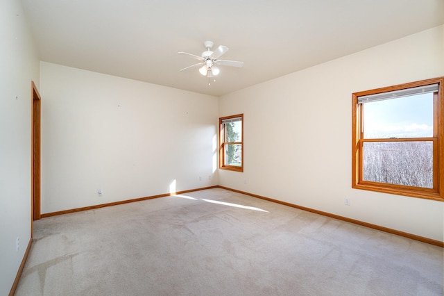 carpeted spare room featuring ceiling fan