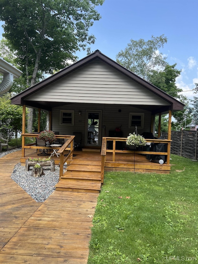 rear view of house with a lawn and a porch