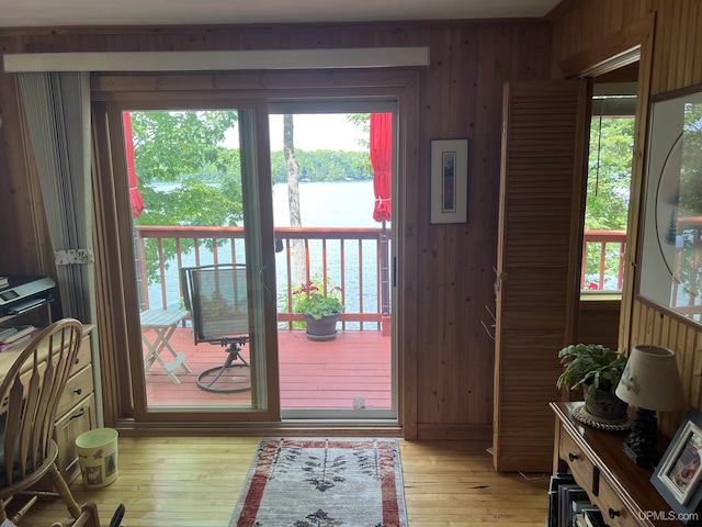 entryway featuring wooden walls, a water view, and light hardwood / wood-style floors