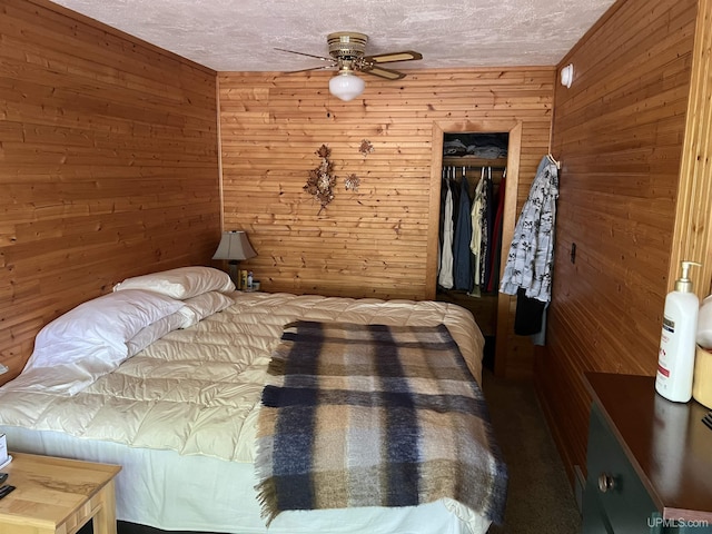 unfurnished bedroom featuring ceiling fan, a textured ceiling, wooden walls, and a closet