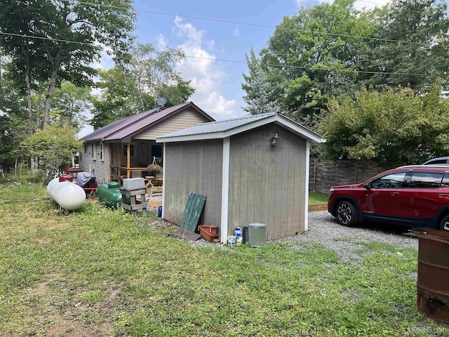 view of side of home with a shed and a yard