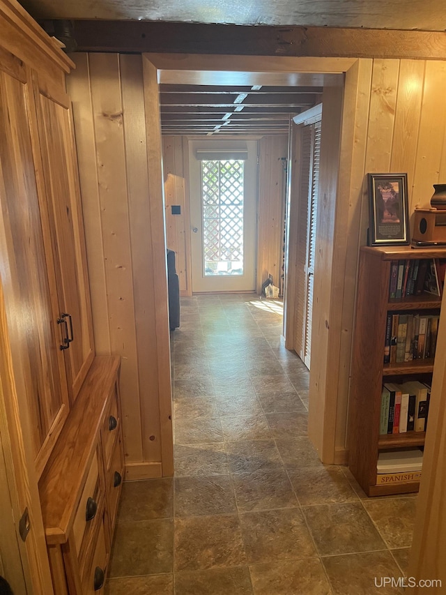 hallway featuring wood walls