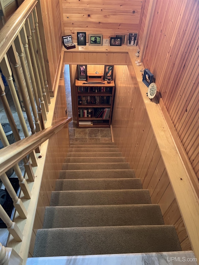 staircase featuring wood walls