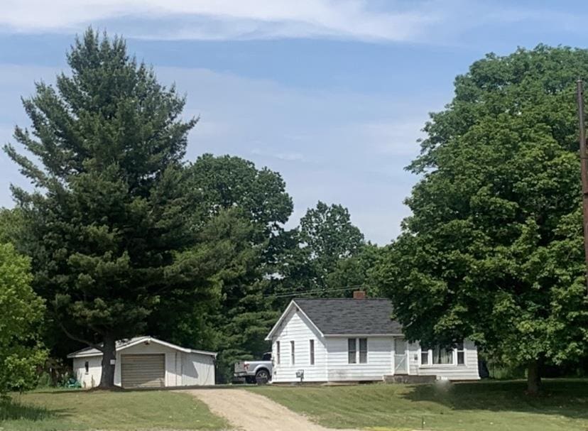 view of front of property with a front yard, an outbuilding, and a garage