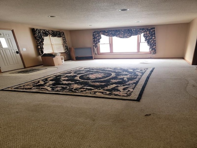 unfurnished living room with carpet floors and a textured ceiling