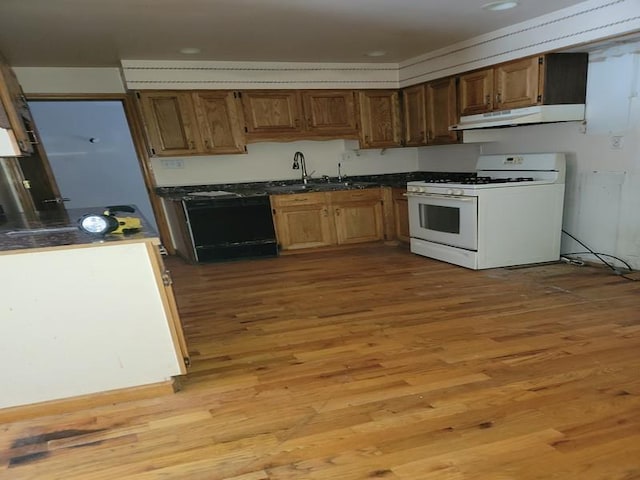 kitchen featuring sink, dishwashing machine, light wood-type flooring, and white gas range oven