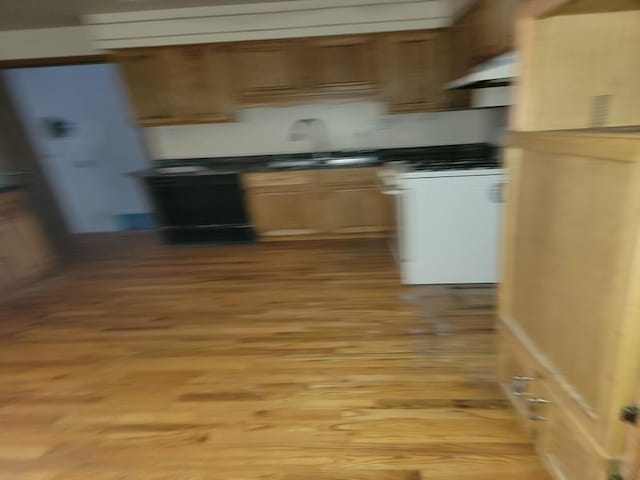 kitchen with sink, white range with gas stovetop, light hardwood / wood-style floors, and range hood