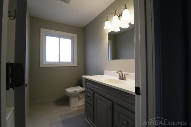 bathroom with vanity, an inviting chandelier, and toilet