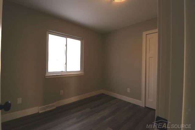 empty room with dark wood-type flooring