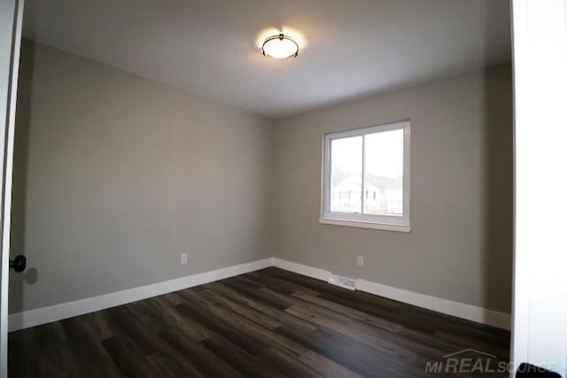 spare room with dark hardwood / wood-style floors