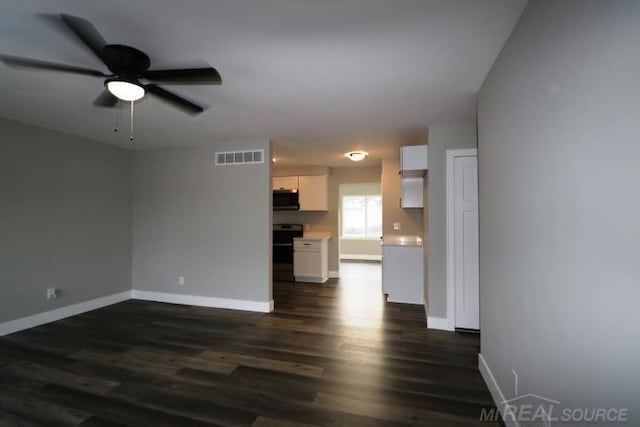 unfurnished living room featuring visible vents, baseboards, ceiling fan, and dark wood-style flooring