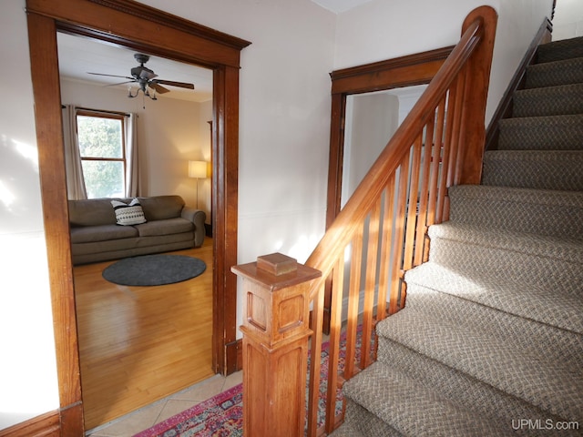 staircase featuring ceiling fan and tile patterned flooring