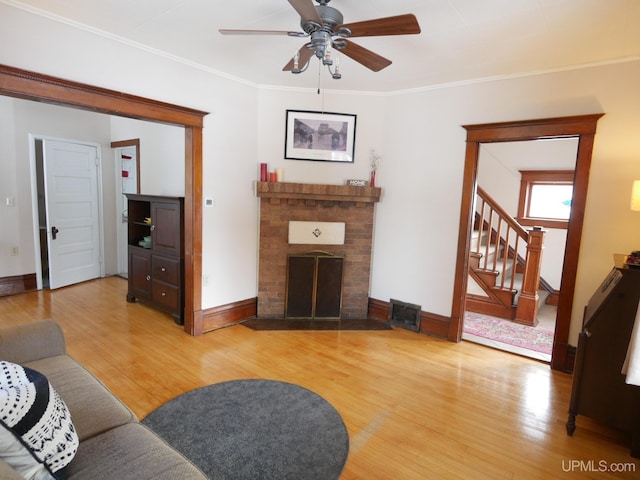 living room with a fireplace, hardwood / wood-style floors, and ornamental molding