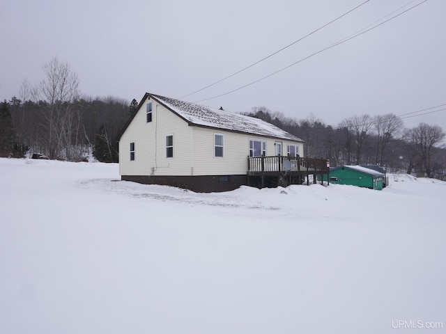 snow covered property with a wooden deck