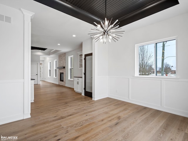 interior space with a notable chandelier, a fireplace, and light hardwood / wood-style flooring