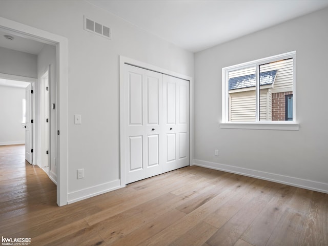 unfurnished bedroom featuring light hardwood / wood-style floors and a closet